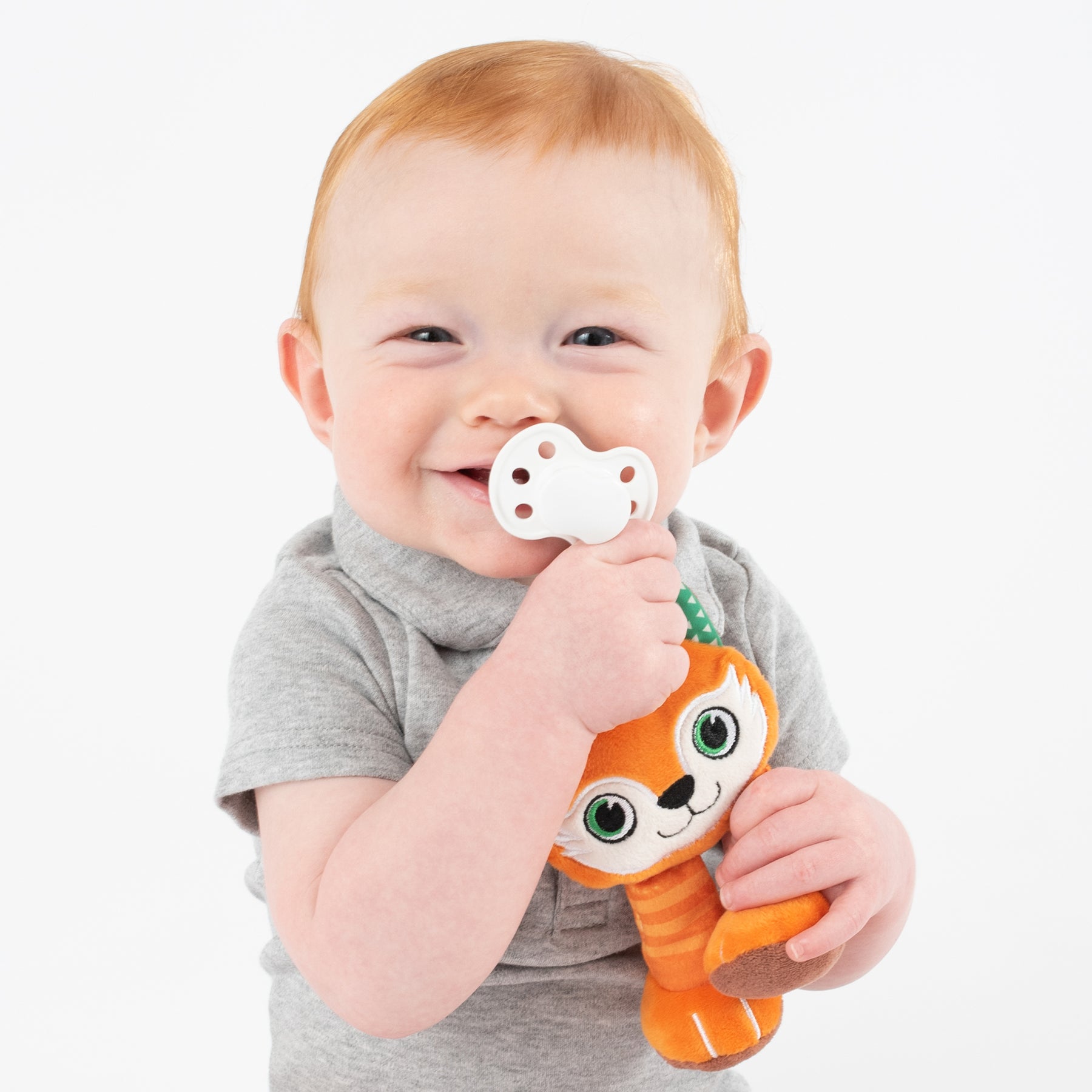 Happy baby boy uses BooginHead Plush pacifier holder Red Fox