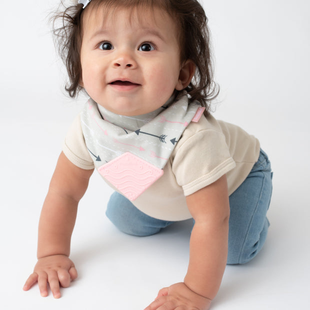 Baby girl wearing BooginHead Bandana Bib in Arrows with pink and gray designs 
