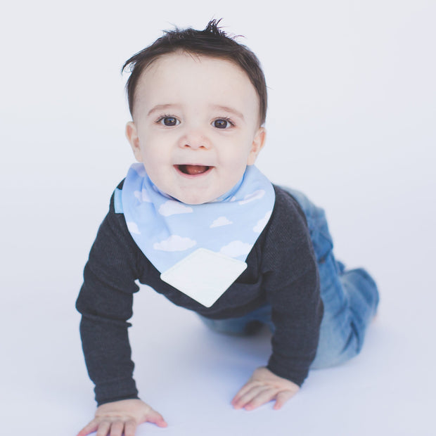 Baby boy wearing BooginHead Bandana Bib in  Blue Sky with soft blue and white cloud designs 