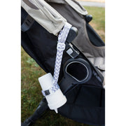 Toddler sippy cup attached to a stroller to keep it from dropping. BooginHead SippiGrip in Chevron, gray and white.