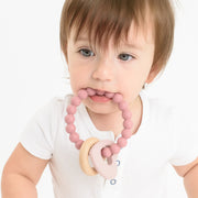 Baby using BooginHead silicone & wood teether, pink heart